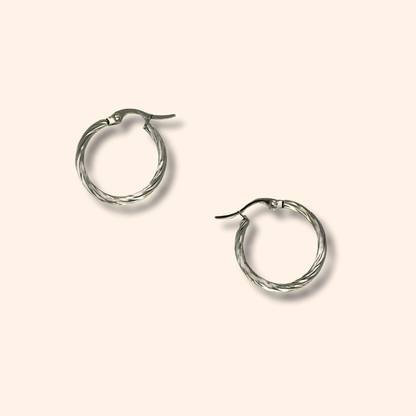 Two timeless Silver Small Spiral Hoop Earrings by Roots Jewellery, showcasing a twisted design, set against a light beige background.