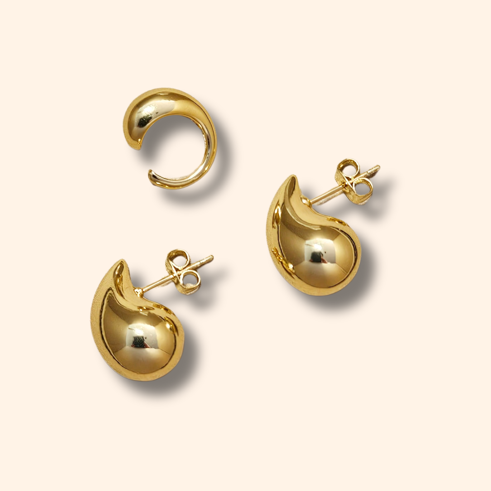 Teardrop Earrings by Roots Jewellery, crafted in gold or silver with a graceful curve that evokes an ear cuff, are showcased against a light background.