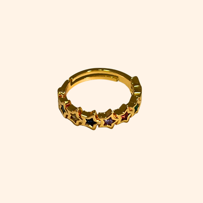 The Rainbow Stars Gold Ring from Roots Jewellery captivates with its star pattern, each embellished with shimmering gemstones. Its simple background is elevated by rhodium plating, providing a sleek finish. The adjustable design guarantees a perfect fit for any occasion.