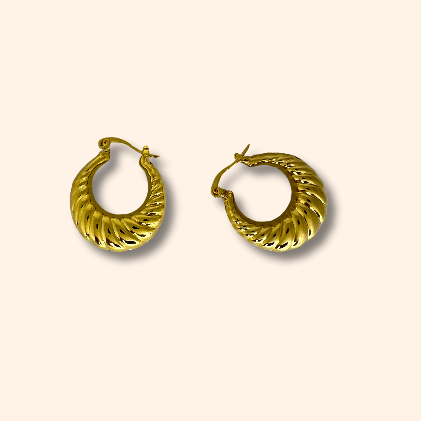 A pair of luxurious Gold Croissant Hoop Earrings from Roots Jewellery, boasting a textured, spiral design set against a neutral background.