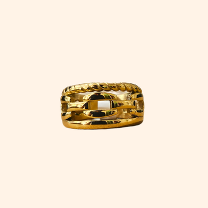 A Chain Gold Ring by Roots Jewellery, featuring a timeless interwoven design, graces a beige background.