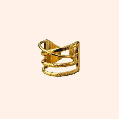 The Intertwined Gold Ring from Roots Jewellery showcases timeless elegance with its wide band and contemporary, intersecting geometric design.