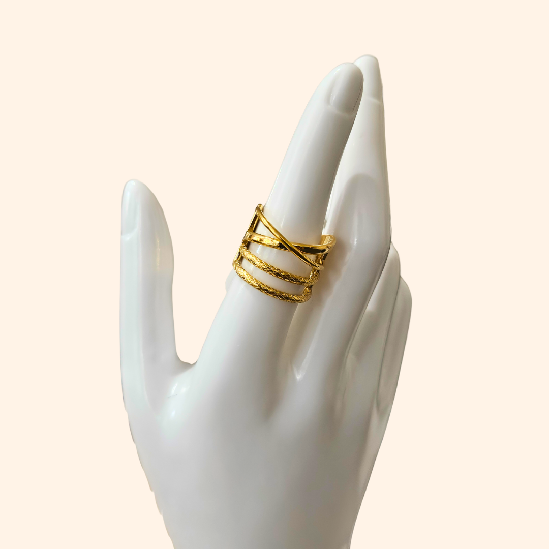 The Intertwined Gold Ring from Roots Jewellery showcases timeless elegance with its wide band and contemporary, intersecting geometric design.