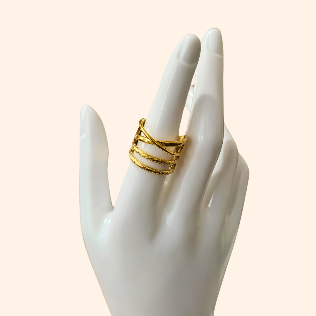 The Intertwined Gold Ring from Roots Jewellery showcases timeless elegance with its wide band and contemporary, intersecting geometric design.