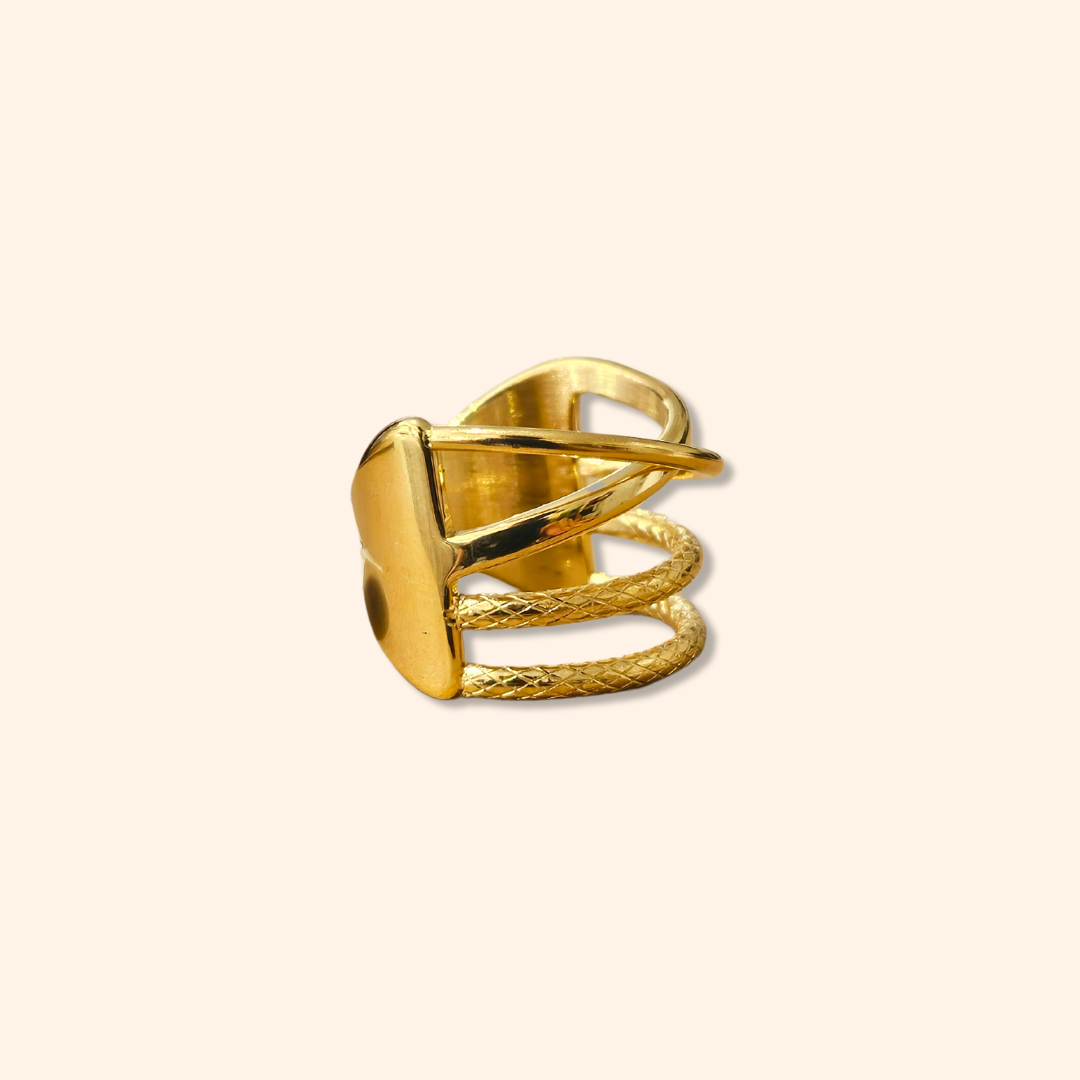 The Intertwined Gold Ring from Roots Jewellery showcases timeless elegance with its wide band and contemporary, intersecting geometric design.