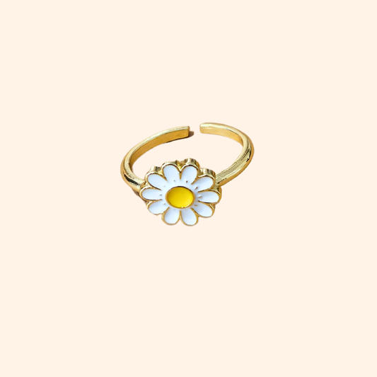 Explore the Daisy Gold Ring by Roots Jewellery, a striking piece adorned with a white and yellow daisy set against a sleek, neutral background.