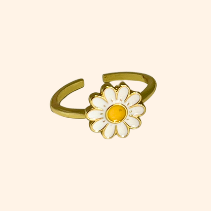 Explore the Daisy Gold Ring by Roots Jewellery, a striking piece adorned with a white and yellow daisy set against a sleek, neutral background.