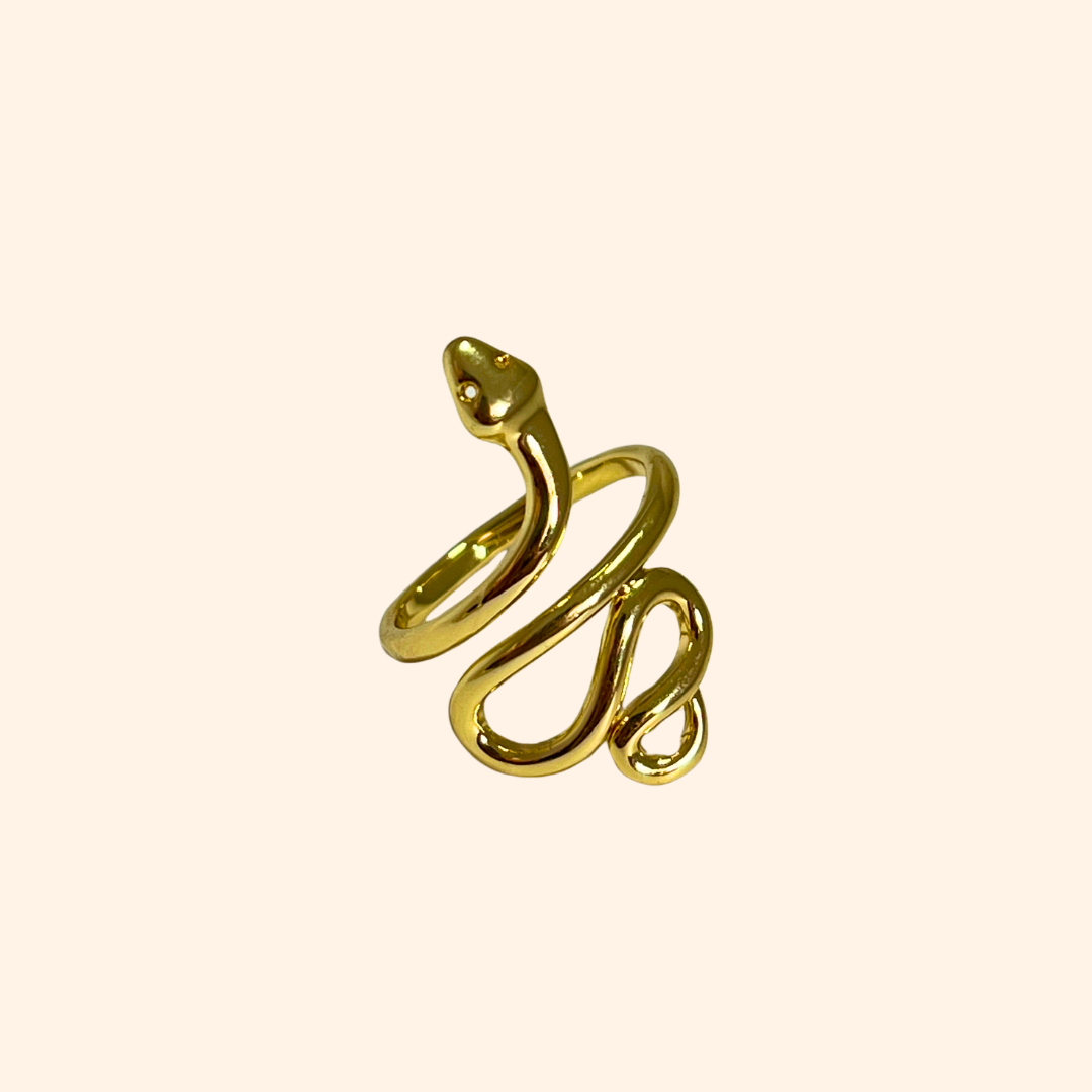 Explore the captivating Snake Gold Ring by Roots Jewellery, elegantly crafted with an adjustable design to ensure a perfect fit. This striking statement piece, set against a plain background, highlights its intricate serpent form and luxurious golden sheen.