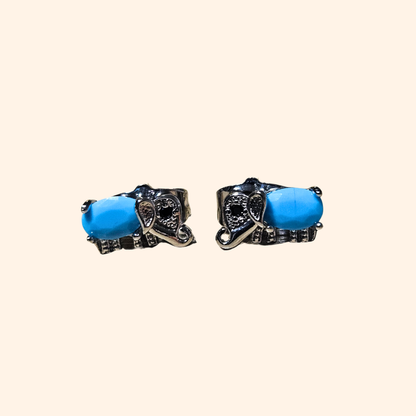 Introducing the Blue Gem Silver Elephant Earrings by Roots Jewellery, crafted in an ornate metal design with exquisite blue gems that resemble elegant silver elephants.