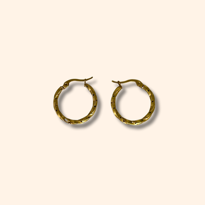 Two Gold Small Spiral Hoop Earrings by Roots Jewellery, featuring versatile clasp closures, rest elegantly on a light beige background.