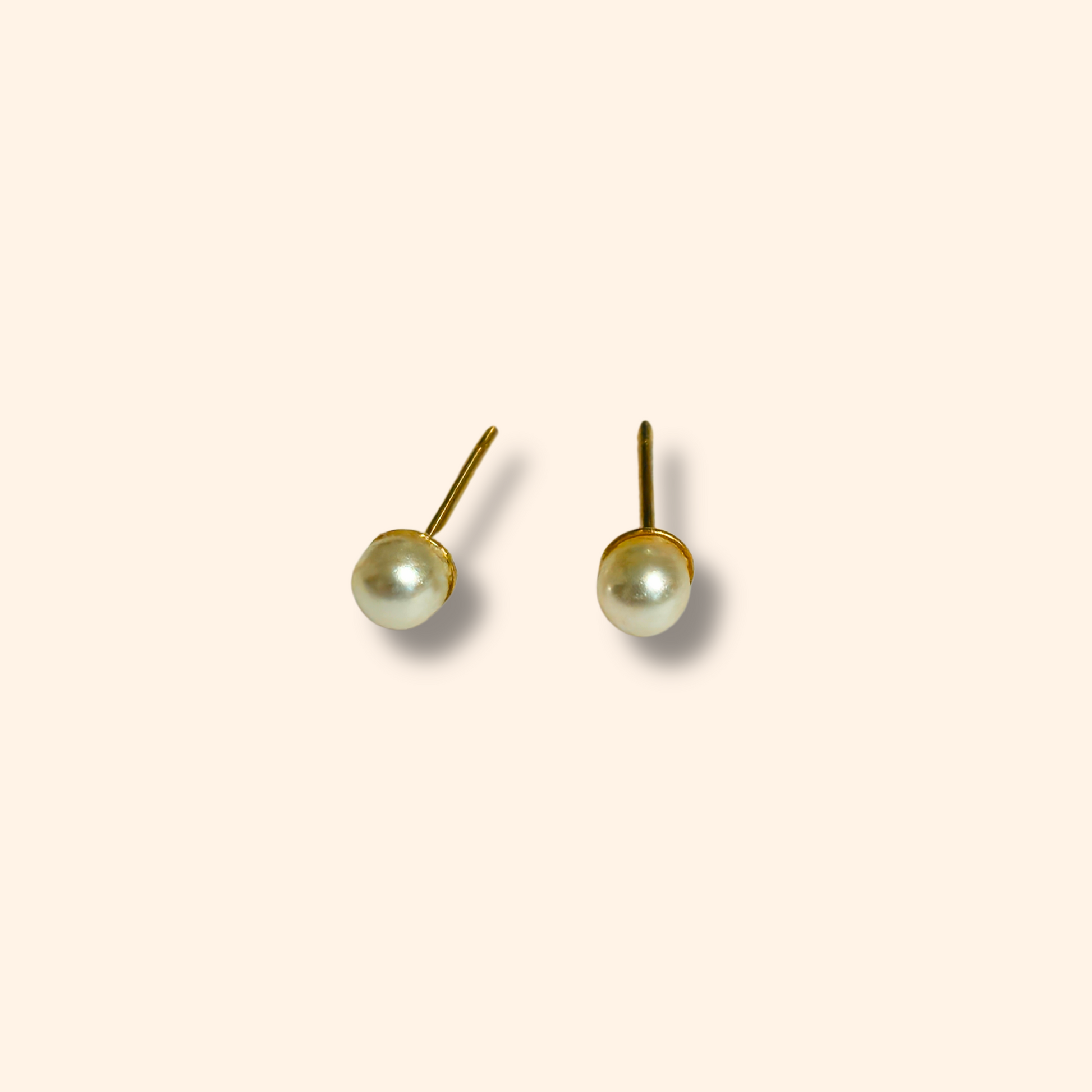 Introducing the Earring Set - Orange Hearts by Roots Jewellery: three exquisite pairs of earrings, including orange heart-shaped, gold flower-shaped, and white pearl studs, all beautifully displayed on a simple backdrop.