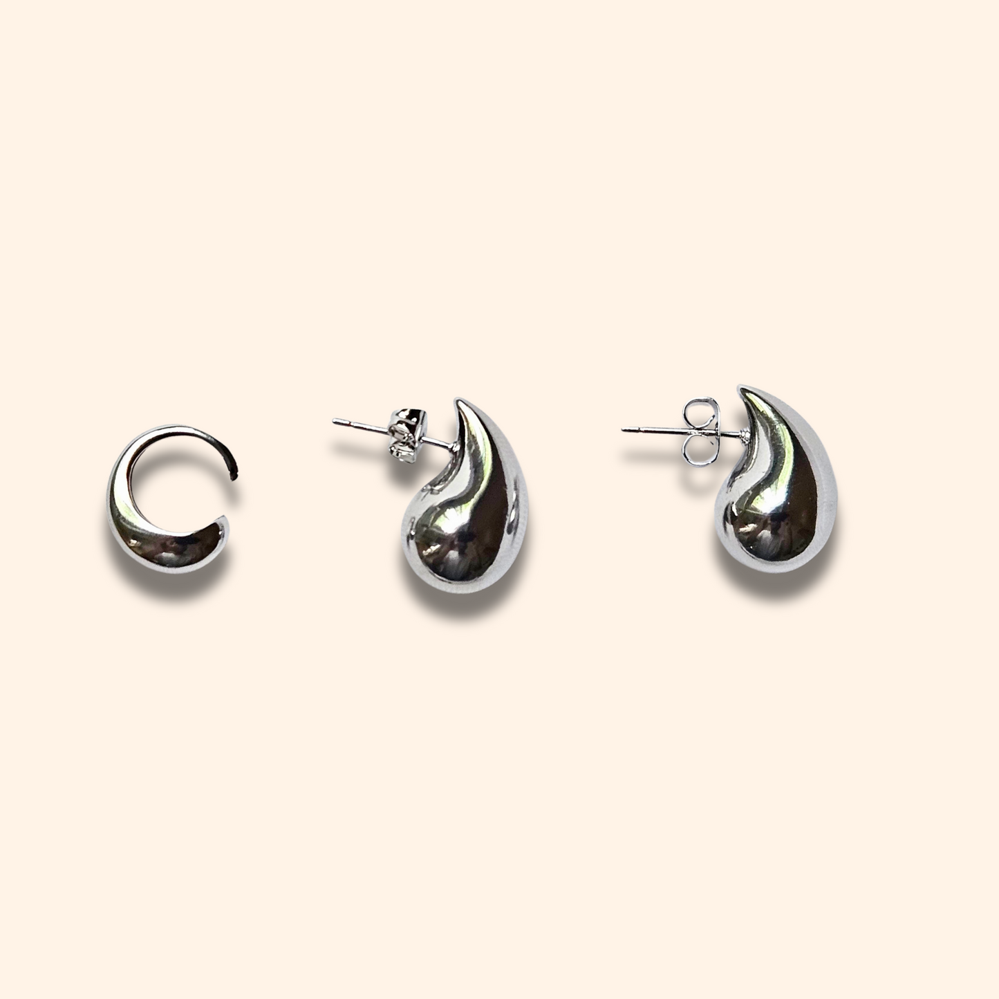 Teardrop Earrings by Roots Jewellery, crafted in gold or silver with a graceful curve that evokes an ear cuff, are showcased against a light background.