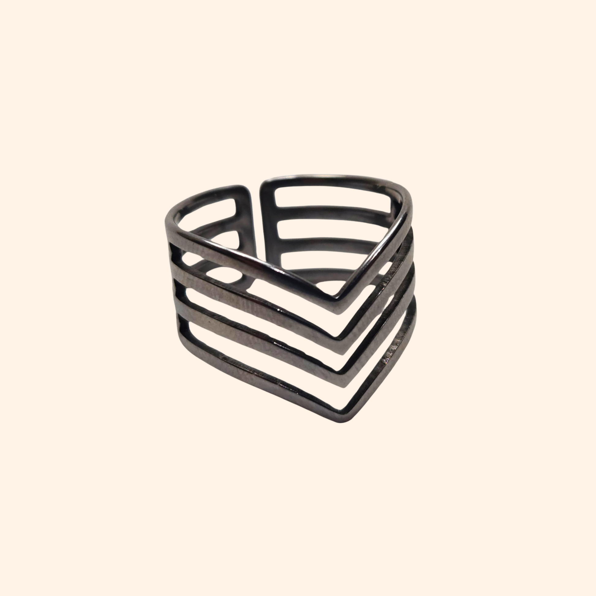 The *Triangle Ring* by Roots Jewellery exudes a contemporary design, boasting geometric, layered patterns with horizontal and V-shaped cutouts crafted in stainless steel.