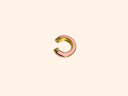 The Single Colour C Shape - Ear Cuff by Roots Jewellery is a small gold and teal ear cuff that elegantly showcases its intricate gold design, set against a beige background, highlighting this exquisite jewelry accessory.