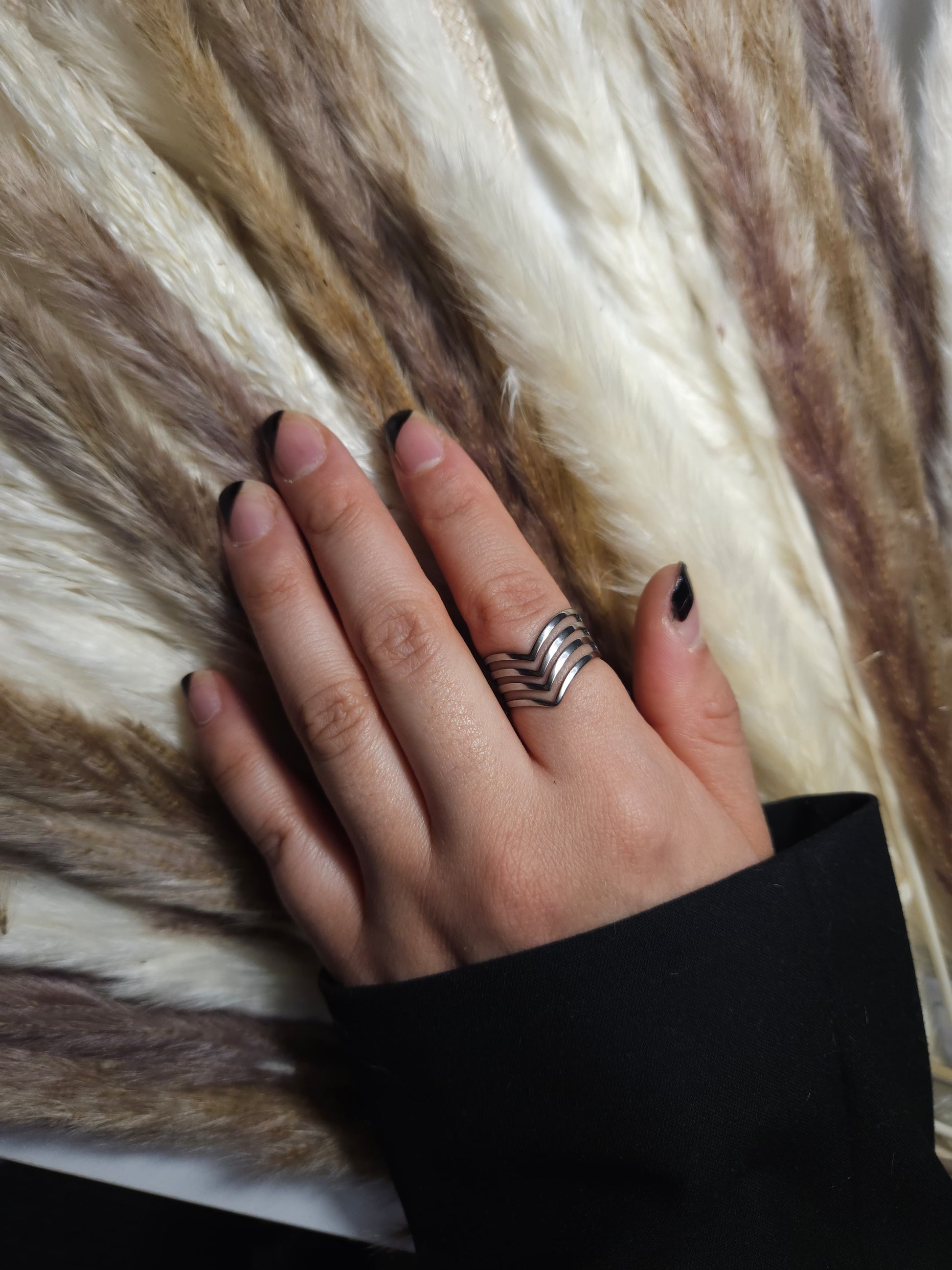 The *Triangle Ring* by Roots Jewellery exudes a contemporary design, boasting geometric, layered patterns with horizontal and V-shaped cutouts crafted in stainless steel.